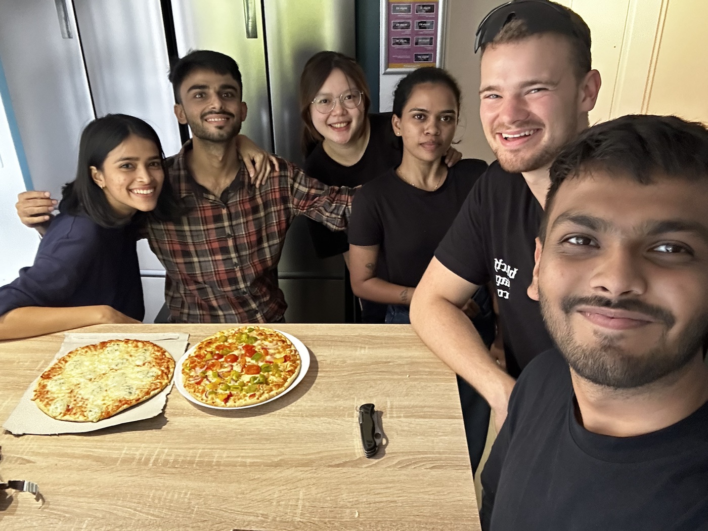 Friends gathered around two homemade pizzas at EDHEC Lille